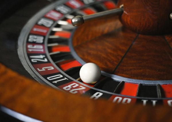 Detailed close-up image of roulette wheel highlighting numbers and spinning ball in a casino setting.